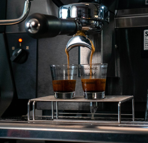 two shots of espresso being poured from machine