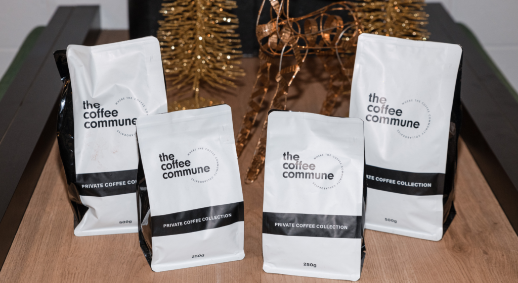 four bags of coffee commune coffee with christmas decoration in the background